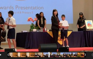 Zachary Low receiving his award for being Top in P4 Maths at ACS Primary School